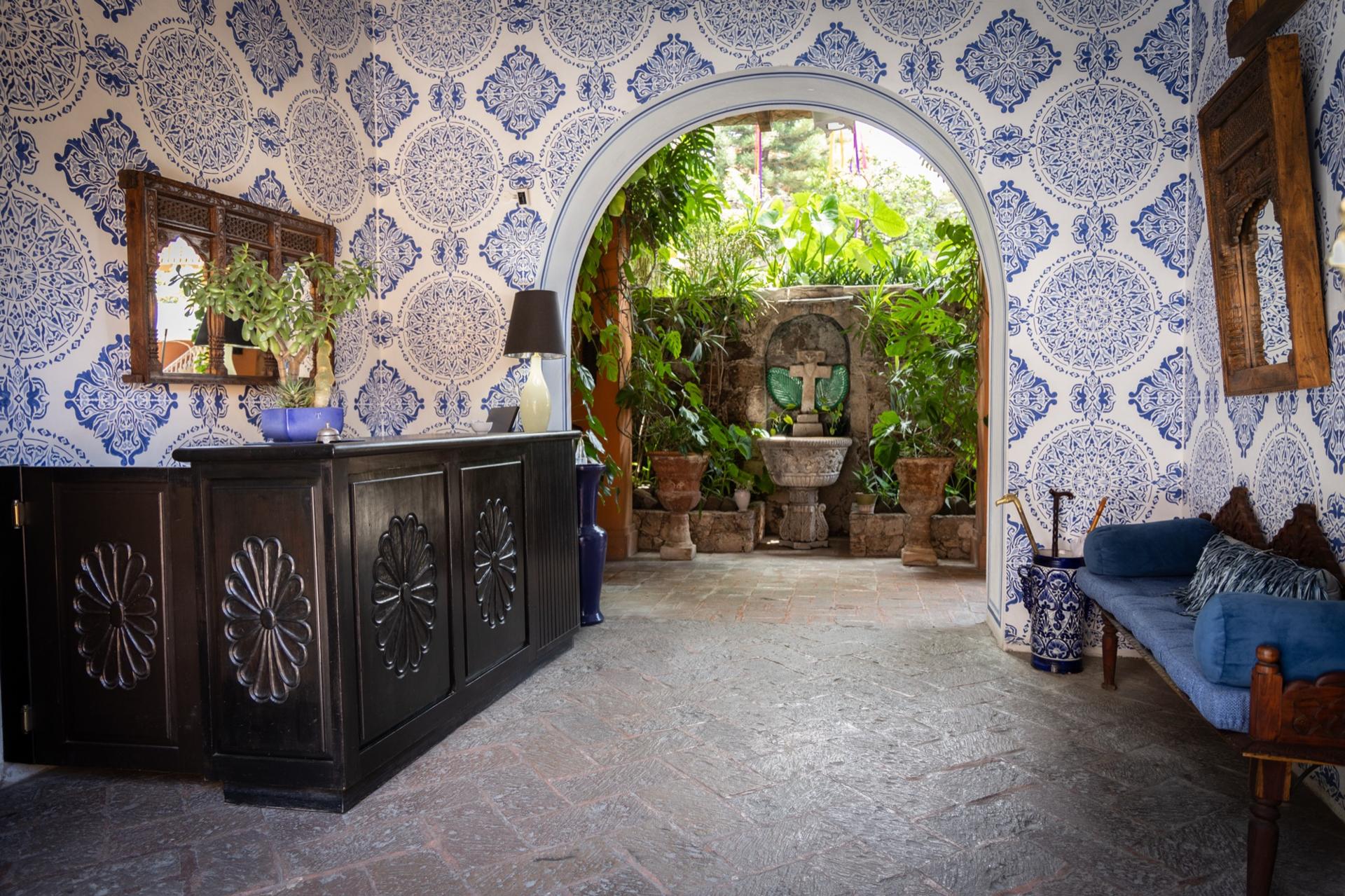 Casa Schuck courtyard bathed in golden hour light with lush greenery and colonial arches